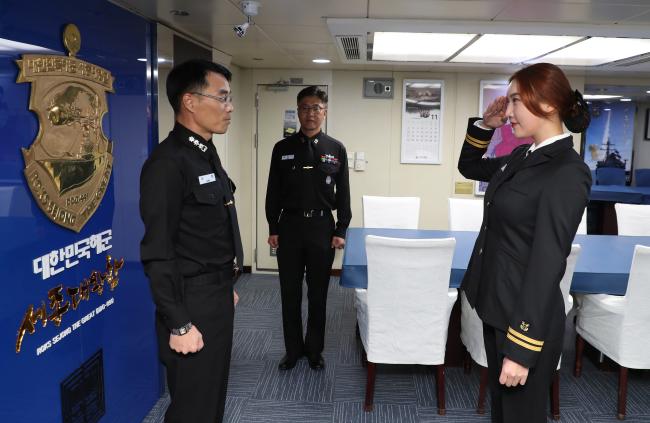 임 위원이 본격적인 훈련 체험에 앞서 장훈(대령) 세종대왕함장에게 일일 승조원 전입을 신고한 뒤 경례하고 있다. 