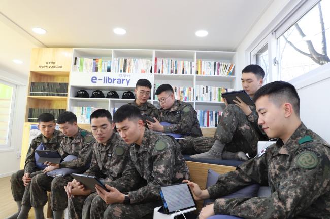 5일 육군28사단 강철대대 장병들이 육군과 롯데그룹이 조성한 ‘e-라이브러리 카페’에서 태블릿PC를 이용해 독서하고 있다.  육군 제공