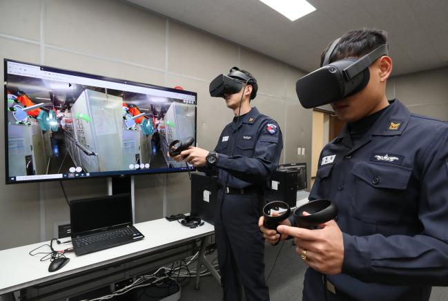 지난 3일 해군잠수함사령부 신기술 아이디어센터에서 가상현실(VR) 기기를 착용한 잠수함 승조원들이 원격 정비지원체계를 체험하고 있다.  진해=양동욱 기자 