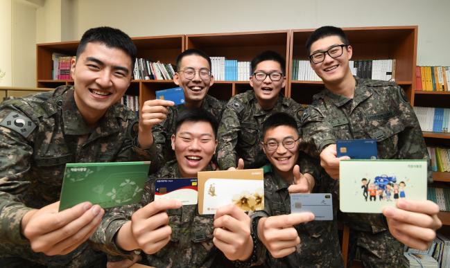 국방부는 올해 병사들의 봉급을 지난해보다 33% 인상 지급한다. 이 밖에도 국방부는 장병들의 복지를 강화하기 위해 올해 다양한 제도를 시행할 계획이다. 사진은 육군3군단 장병들이 인상된 봉급을 활용한 적금 통장과 나라사랑카드를 들고 환하게 웃는 모습.  국방일보 DB