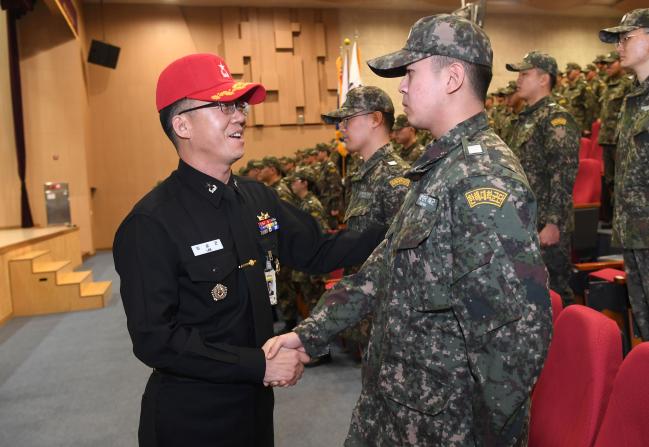 13일 해군교육사령부 종합교육관 대강당에서 열린 ‘학군사관후보생 동계입영훈련 입영식’에서 이상곤(왼쪽) 기초군사교육단장이 한 후보생과 악수하고 있다.  사진 제공=박미현 중사