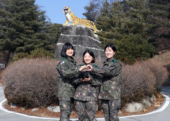 육군수도기계화보병사단 박하늘·박아라 중사, 김윤아 중위(왼쪽부터)가 소아암 환우들에게 기증할 머리카락을 들고 손 하트를 그리며 기념사진을 찍고 있다.  부대 제공