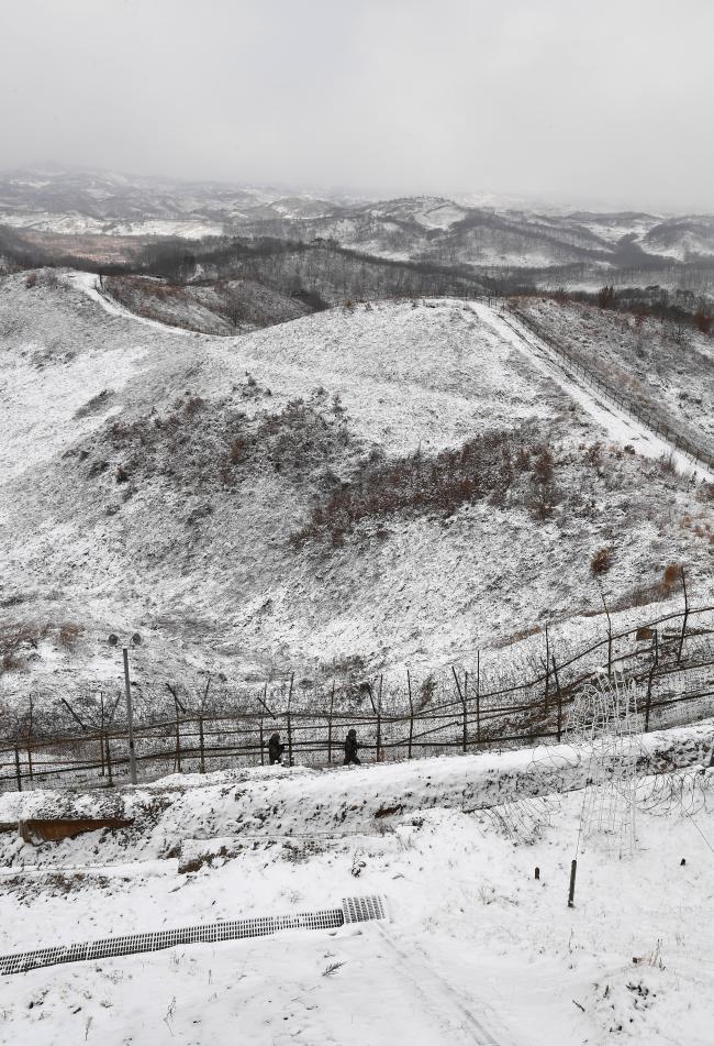 전날부터 새벽까지 내린 함박눈으로 DMZ 일대가 하얗게 덮인 지난 17일 경기도 서부전선에서 육군25사단 예하 해룡연대 상승대대 GOP 장병들이 초소 경계근무 교대를 위해 남방한계선 철책을 따라 이동하고 있다. 과학화경계시스템 도입으로 철책을 따라 걸으며 눈으로 감시하는 육안 철책점검은 최소화됐지만 주요 거점 고가초소에는 병력이 상시 배치돼 GOP 완전작전을 완수하고 있다.