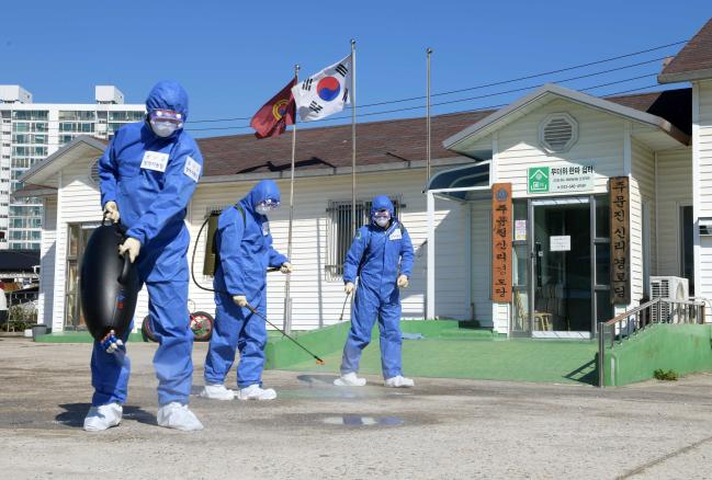  공군18전투비행단 장병들이 18일 강릉시 주문진읍 신리경로당에서 코로나19 확산 방지를 위한 방역활동을 하는 모습.  부대제공