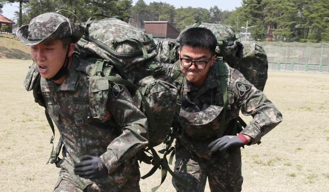 지난 9일 게임식 교육훈련 ‘백마그라운드’에 참가한 육군35사단 백마연대 장병들이 완전군장을 메고 골인 지점을 향하던 중 지친 전우의 등을 밀어주며 전력 질주하고 있다.     이경원 기자