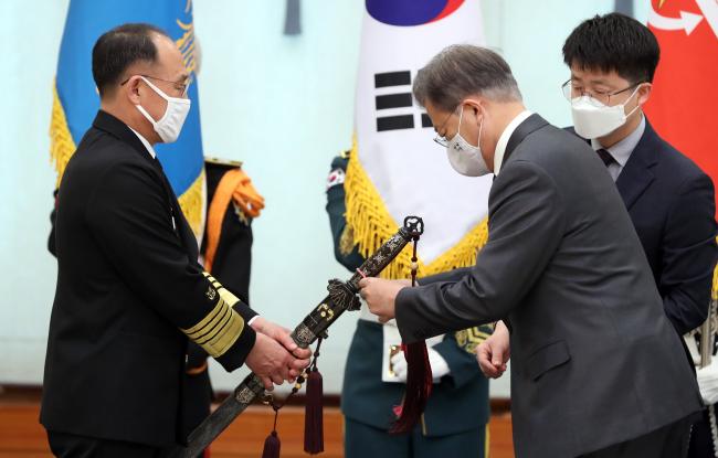 문재인 대통령이 지난 10일 오후 청와대에서 부석종 해군참모총장의 진급 및 보직신고를 받은 후 삼정검(三精劍)에 수치를 달아주고 있다. 청와대