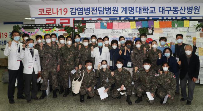 대구 동산병원 1차 군 의료지원팀원들이 지난달 21일 임무를 마친 뒤 동산병원 의료진과 기념사진을 찍고 있다.  양동욱 기자