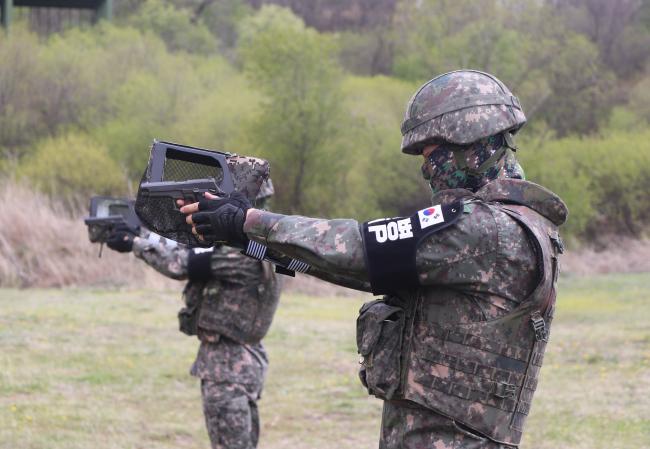 육군6사단 수색대대원이 팔목에 권총 탄피받이를 착용한 상태로 권총 사격을 하고 있다.
  부대 제공