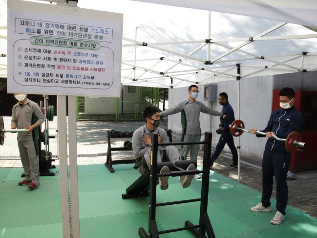 육군2작전사령부 화생방대대 장병들이 ‘생활 속 거리 두기’를 적용한 병영생활문화 정착의 하나로 야외체력단련장에서 체력단련을 하고 있다.  부대 제공