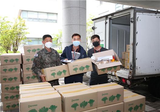군사안보지원사령부 임대기(왼쪽) 중령이 지역 농산물 구매 행사를 위해 농가에서 농산물을 받은 뒤 기념사진을 찍고 있다.  부대 제공