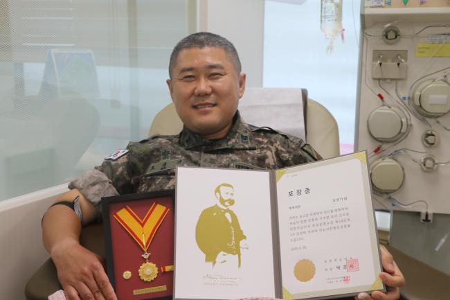 육군17사단 오성기 상사가 헌혈 200회 달성 후 명예대장을 들어 보이고 있다.  부대 제공