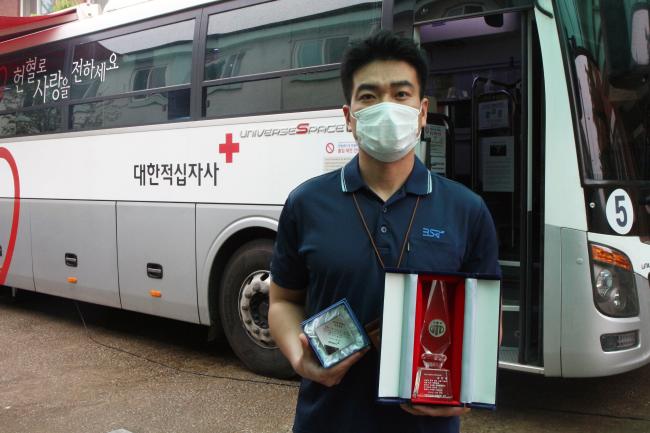 이혜선 주무관이 그동안 모은 헌혈증을 들어보이고 있는 모습(왼쪽)과 김민욱 주무관이 조혈모세포 공여 감사패를 들고 기념사진을 찍고 있는 모습. 부대 제공