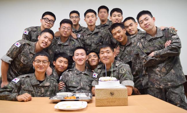 육군25사단 번개포병대대 행정보급관 주현덕(앞줄 맨 오른쪽) 상사가 생일을 맞은 조용호(앞줄 가운데) 상병을 위해 손수 끓인 미역국과 케이크를 전달한 뒤 기념사진을 찍고 있다.  부대 제공