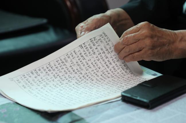 신현우 옹이 을지무공훈장을 받은 장단 사천지구전투 내용을 기록한 원고를 펼쳐 보이고 있다. 사진=양동욱 기자 