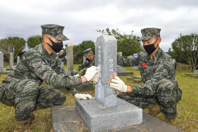 해병대 9여단 장병들이 추석을 앞두고 제주지역 내 충혼묘지에서 묘비를 닦고 있다.  부대 제공