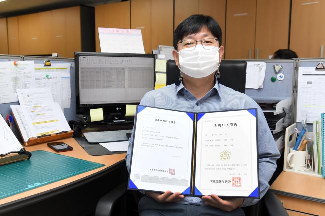 '공군 군무원 최초 건축사’라는 쾌거를 이룬 공군사관학교 공병대대 기술관리실장 이윤수 군무사무관이 건축사 자격증을 들어보이며 기념 촬영을 하고 있다.  사진 제공=김주찬 하사