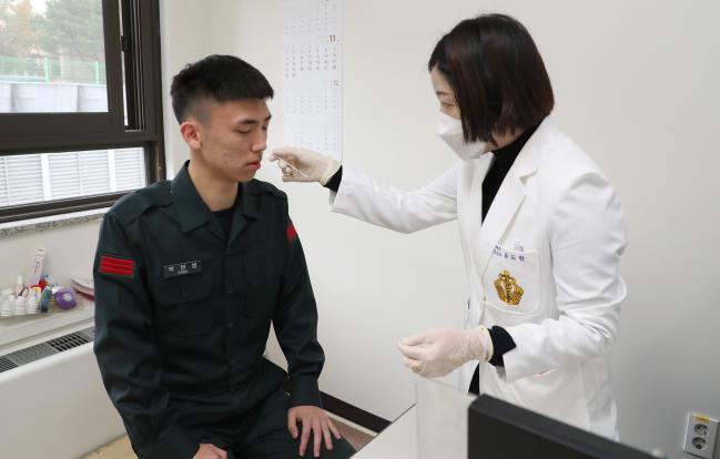 22일 국군수도병원 의료진이 이달 초부터 야전부대와 군 병원 등에 보급되고 있는 ‘독감진단키트’를 활용해 한 병사의 코 점막 검체를 채취하고 있다. 양동욱 기자 