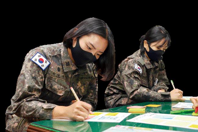  육군12사단 이여린(왼쪽) 하사와 홍옥주 하사가 기증할 모발과 함께 보낼 편지를 작성하고 있다.   부대 제공

