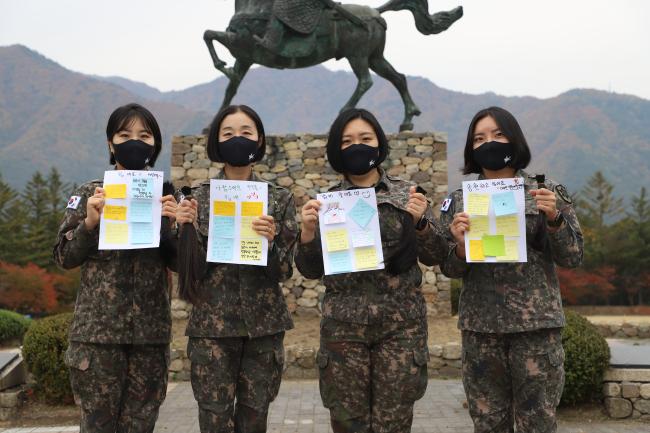 소아암 환우들을 돕기 위해 모발기증에 나선 육군12사단 홍옥주 하사와 김경민 원사, 김은유 중사(진), 이여린 하사(왼쪽부터)가 기증할 머리카락과 직접 쓴 손편지를 들어 보이며 기념사진을 찍고 있다.  부대 제공 