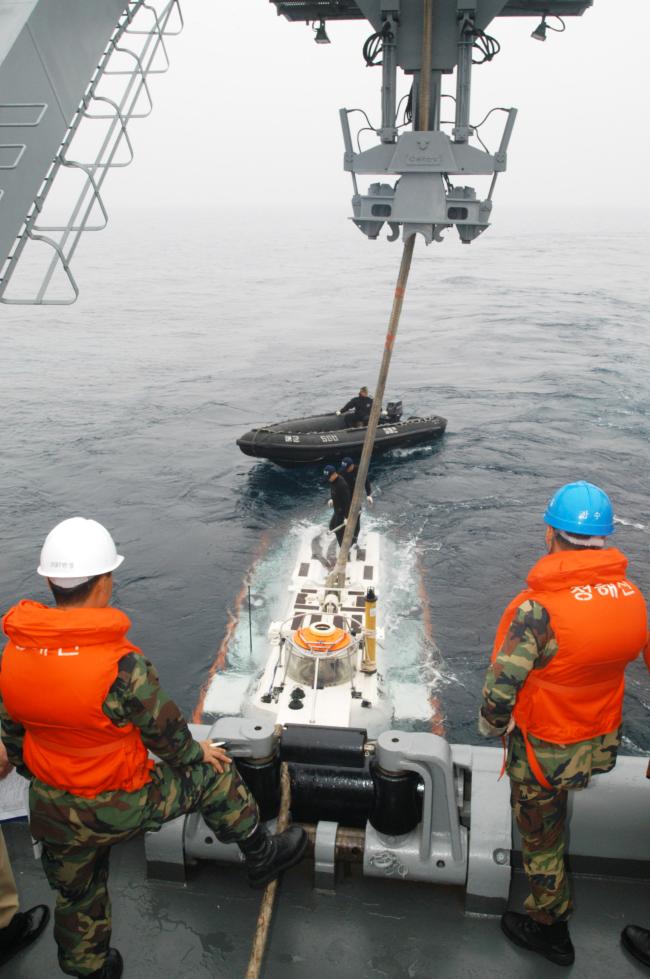 해군 잠수함구조함 청해진함(ASR-21) 장병들이 잠수함 탈출·구조훈련에서 인양 로프를 풀며 투입을 준비하고 있다.  국방일보 DB