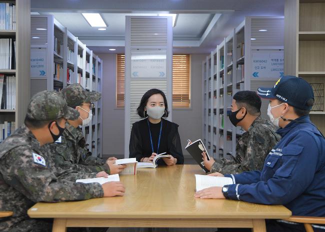 공군10전비 도서 관리 담당 박상희 군무주무관이 부대 장병들과 독서와 관련해 이야기를 나누고 있다. 10전비는 병영 독서문화 활성화에 최선을 다한 결과 2020년 우수도서관 운영 평가에서 최우수 병영도서관에 선정됐다.  사진 제공=전호 하사