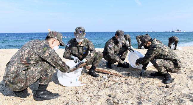 공군18전투비행단 장병들이 부대 인근 해안가에서 쓰레기와 잡목을 수거하고 있다. 

 사진 제공=김동범 중사
