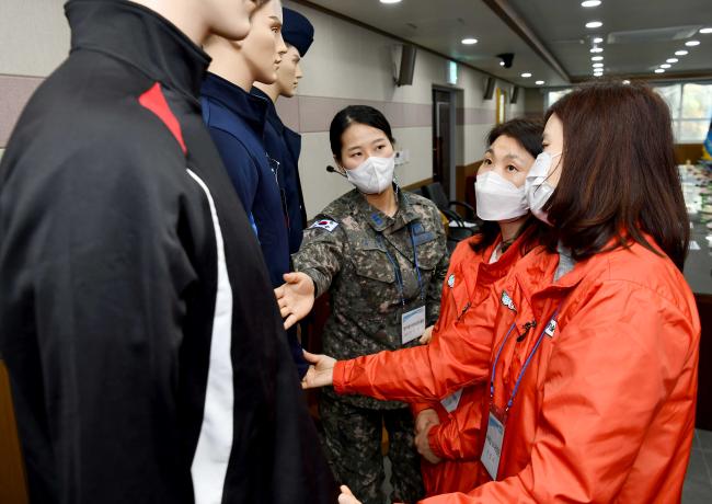 공군19전투비행단 ‘어머니 모니터링단 부대 방문 행사’에서 어머니 모니터링단이 병사들의 전투복·체련복 등 피복류를 만져보며 의견을 제시하고 있다.
 사진 제공=지준오 중사