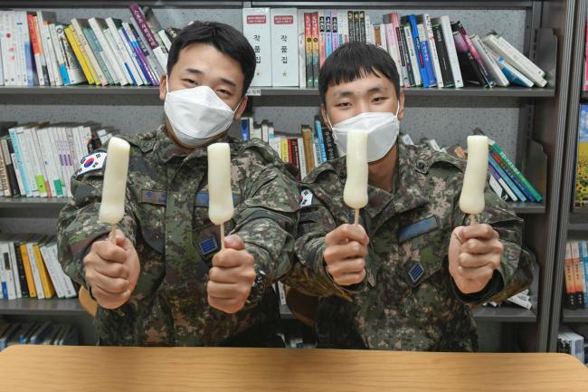 공군1전투비행단 장병들이 가래떡 꼬치를 들어 보이며 포즈를 취하고 있다.  사진 제공=김효진 상병