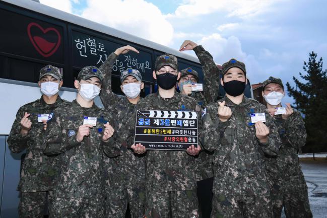 공군3훈련비행단 장병들이 헌혈 후 헌혈버스 앞에서 헌혈증을 들어 보이며 포즈를 취하고 있다.  부대 제공 