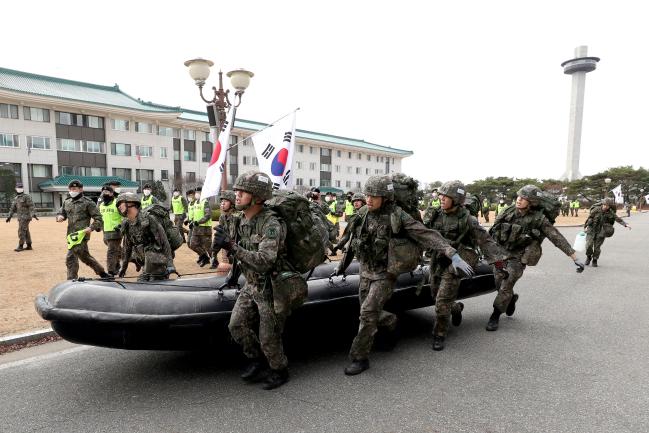 화랑전투기술 경연대회 ‘단정 운반’ 종목에 출전한 생도들이 같은 중대 선후배 생도들의 응원 속에 약 90㎏에 달하는 고무보트와 20L 물통 4개를 들고 화랑관 광장을 달리고 있다.