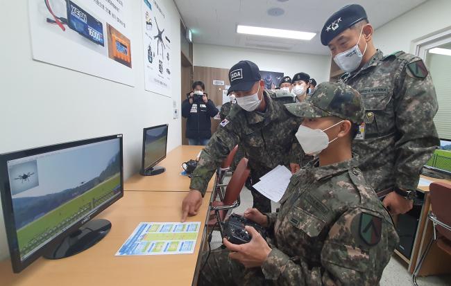 최진규(맨 오른쪽) 수도군단장이 드론교육센터에서 조종 시뮬레이터 조작 시범을 확인하고 있다.  부대 제공