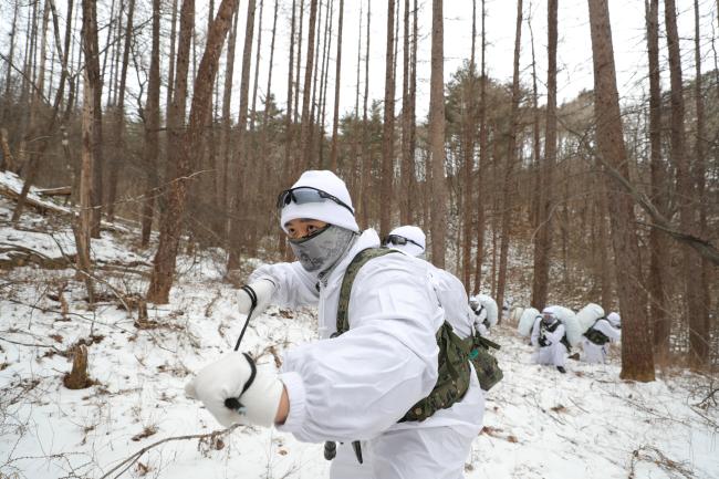 육군특전사 최재만 상사(진)가 포승줄을 들고 상대 경계병을 제압하기 위해 다가가고 있다.