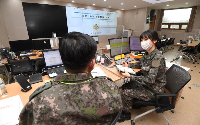 18일 경기 성남 국군의무사령부 방역대책본부에서 강인표(중령·왼쪽) 신속대응과장과 김은희(대위) 감염병대응지원장교가 자체 회의를 하고 있다.  조용학 기자