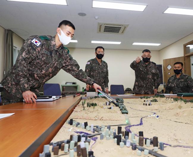 육군7포병여단 간부들이 디오라마 형태로 제작한 모의 사판 앞에서 효과적인 자주포 기동방안을 토의하고 있다.  사진 제공=김정호 중사