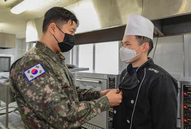 올겨울 식중독 발생 건수가 지난해 같은 기간보다 1.5배 증가함에 따라 국군의무사령부가 겨울철 식중독에 대한 장병·부대의 각별한 주의를 당부했다. 사진은 동절기 급식 관리 및 식중독 예방 활동을 전개하는 해군1함대의 임도훈(왼쪽) 하사가 조리 요원 이민규 상병의 복장을 점검하는 모습.  부대 제공