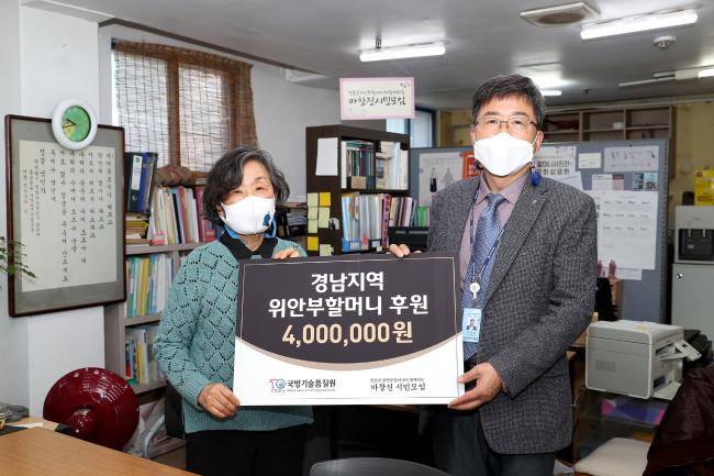 오광섭(오른쪽) 국방기술품질원 경영지원팀장이 경남 지역 위안부 할머니들을 위해 모은 성금을 전달한 뒤 시민단체 대표와 기념사진을 찍고 있다.