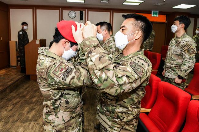 지난 19일 공군5공중기동비행단에서 열린 21-1차 공군 ○○○○○ 초급과정 수료식에서 훈련교관이 수료자에게 빨간 베레모를 씌여주고 있다.  사진 제공=양순호 상사