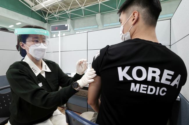 지난달 26일 경기도 성남시 국군수도병원 국군의무근무지원단 생활체육관에서 열린 코로나19 백신 예방접종 모의훈련에서 모의 접종 대상자가 의료진으로부터 모의 접종을 받고 있다.  이경원 기자