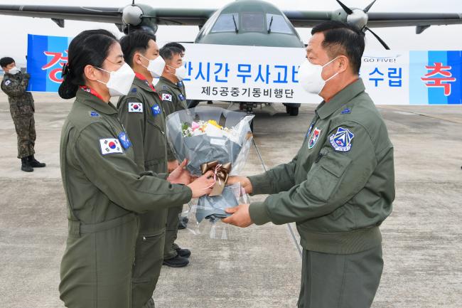 전인석(준장) 공군5공중기동비행단장이 이세리 소령에게 꽃다발을 건네며 ‘24만 시간 무사고 비행기록 수립’ 달성을 축하하고 있다.  사진 제공=양순호 상사 