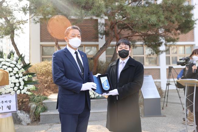 황기철(왼쪽) 국가보훈처장이 10일 인천시 연수구 송도고등학교에서 열린 고 윤영하 소령 추모행사에서 유족 대표에게 ‘국가유공자의 집’ 명패를 전달한 뒤 기념사진을 찍고 있다.  보훈처 제공