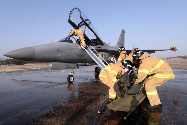 ‘활주로 폐쇄 시 처리훈련’에서 소방 요원들이 사다리를 이용해 FA-50 항공기 조종사를 구조하고 있다. 