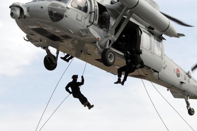해군 군사경찰부대 특임반 대원들이 24일 진해 비행장에서 해상기동헬기에 탑승해 헬기레펠 훈련을 하고 있다.  해군 제공