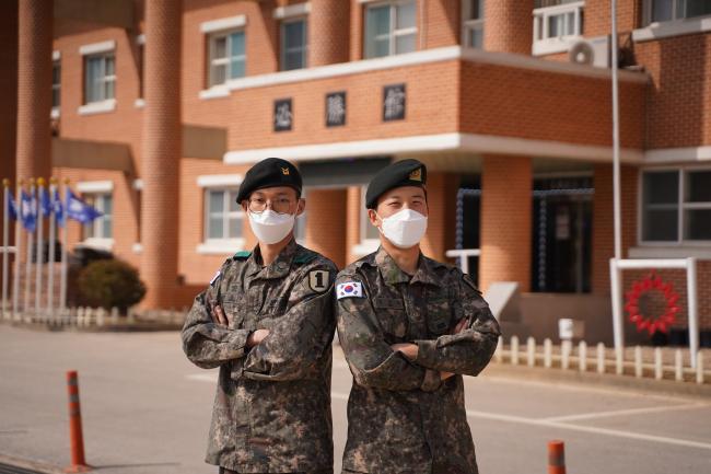 육군과학화전투훈련단 훈련을 앞두고 전역을 2개월 연기한 변준엽(왼쪽) 하사와 할머니상에도 불구하고 훈련 참여를 결정한 김진욱 상병이 포즈를 취하고 있다. 변 하사와 김 상병을 포함한 육군1사단 장병 16명은 예정된 전역일을 연기하거나 휴가를 반납하며 훈련에 동참했다.  사진 제공=김병훈 중위 