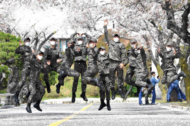 해군사관학교 장병들이 벚꽃이 만개한 교내에서 봄기운을 만끽하며 포즈를 취하고 있다.  해사 제공