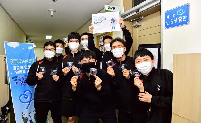 공군인권나래센터에서 주관한 ‘제1호 인권 우수 생활관’에 선정된 공군정보체계관리단 7생활관 병사들이 선물 받은 휴대전화 액세서리 그립톡을 들어 보이며 환하게 웃고 있다.  공군 제공 