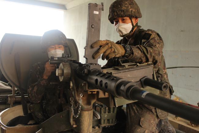 여단 전투지휘검열에 참가하고자 최근 전역을 일주일 연기한 육군2기갑여단 번개대대 안대희 병장이 후임병에게 K6 기관총 운용 노하우를 전수하고 있다.  부대 제공 