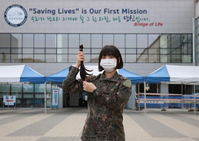 국군수도병원 현세연 육군대위(진)가 소아암 환자를 위해 기른 머리카락을 들어 보이고 있다.  부대 제공