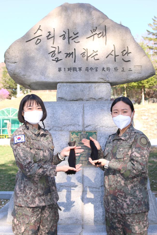 육군15사단 이수진(오른쪽) 중사와 김연화 하사가 약 1년 동안 소중히 길러온 머리카락을 자른 뒤 기념사진을 찍고 있다.  부대 제공