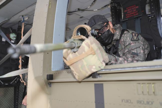 육군1군단 흑표범부대 저격수가 13일 한국형 기동헬기(KUH-1) 수리온을 이용해 공중사격 훈련을 하고 있다. 16명의 저격수가 참가한 훈련은 헬기 기동사격 때 효과적인 사격 방법을 모색하고, 고도에 따른 사각 데이터를 산출하기 위해 추진됐다.  조종원 기자 