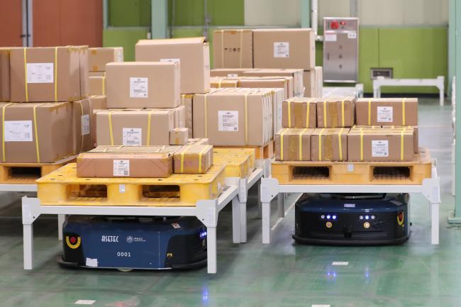 자율이송로봇들이 색출대기공간에서 보급품이 실린 파레트를 작업자가 있는 곳으로 옮기고 있다. 사진=조종원 기자
